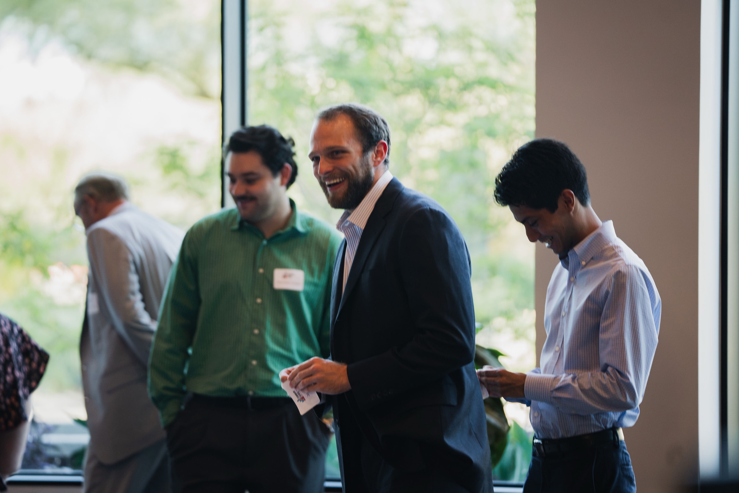 Joe Pitts laughing with colleagues at a networking event